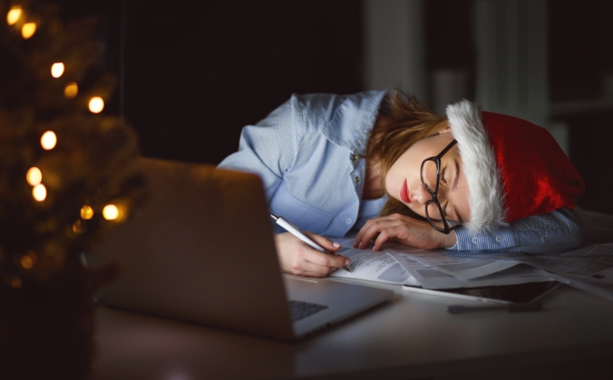 Woman in Christmas hat asleep at her laptop