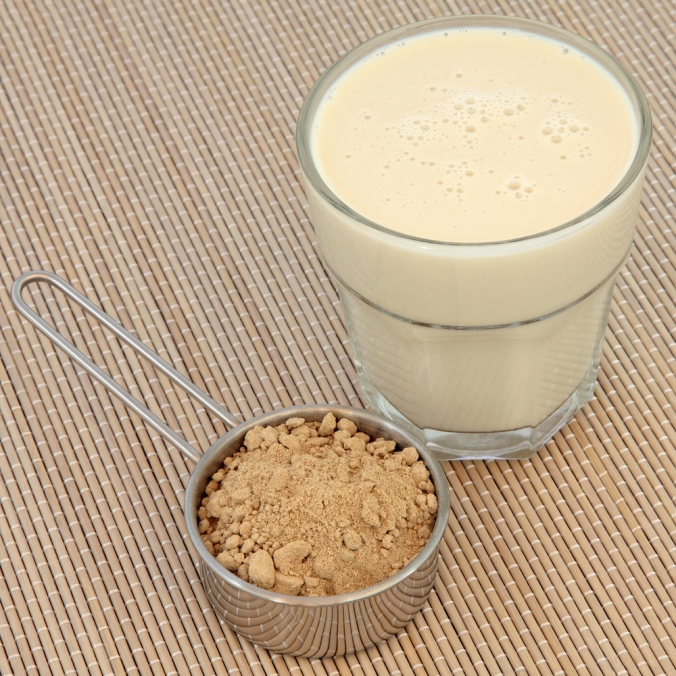 Pot of maca powder and glass of milk with maca