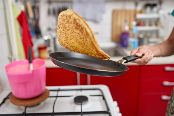 Close up of a pancake being tossed in a pan